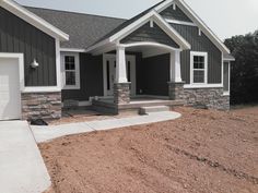 a gray house with white trim and two garages