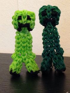 two small crocheted objects sitting on top of a wooden table next to each other