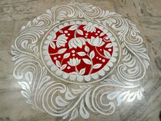 a red and white circular design on a marble floor