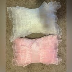 two pillows that are sitting on the floor next to each other with ruffles