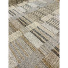 an area rug with different colors and patterns on the floor, including beiges, browns