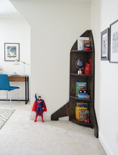 a room with a book shelf and superman figure