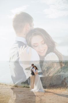 a man and woman standing next to each other on top of a hill near the ocean