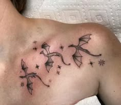 a woman with a tattoo on her chest and some stars in the sky above her shoulder