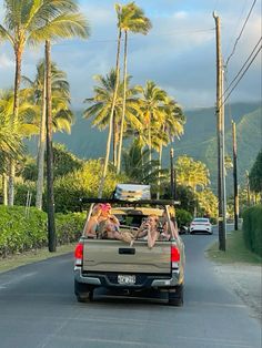 two women are riding in the back of a pick up truck