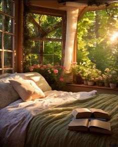 an open book laying on top of a bed in front of a window filled with flowers