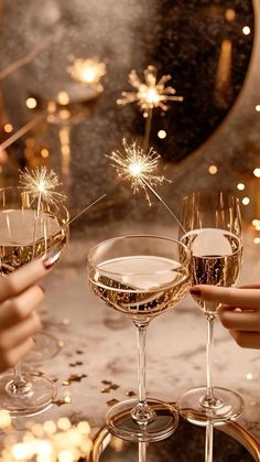 two glasses of champagne being toasted with sparklers