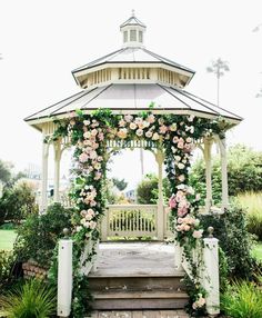 a gazebo covered in flowers and greenery