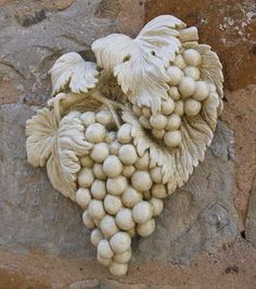 a bunch of white grapes sitting on top of a stone wall