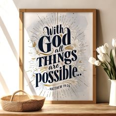 a framed poster with the words, with god all things are possible on it next to a basket and flowers