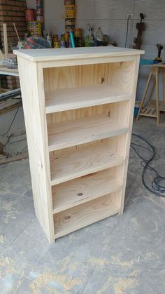 a wooden book shelf sitting inside of a garage