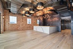 an empty room with exposed brick walls and wooden floors