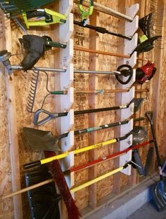 there are many skis and snowboards on the rack in this room, all lined up against the wall