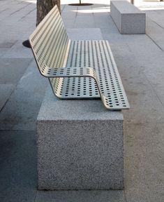 a metal bench sitting next to a tree