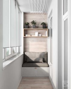 a long narrow hallway with white walls and wooden shelves on the wall, filled with potted plants