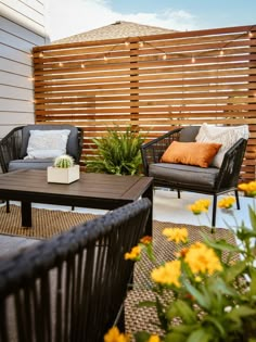 an outdoor seating area with chairs, table and potted plants