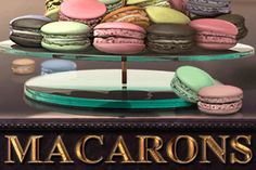 macarons are stacked on top of each other in front of a sign that says macaroons