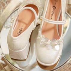 two pairs of white shoes sitting on top of a glass table