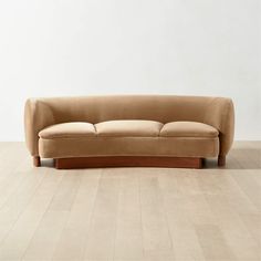 a tan couch sitting on top of a wooden floor