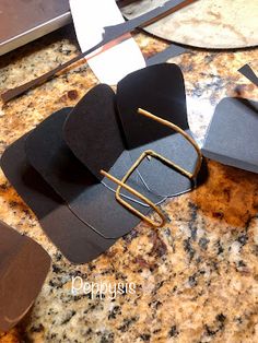 a pair of black paper clips sitting on top of a counter next to a knife