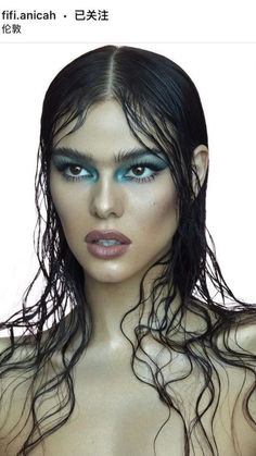 a woman with wet hair and blue eyes is posing for the camera while wearing green makeup