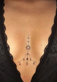 a woman's chest with an arrow and stars tattoo on her left side ribcage