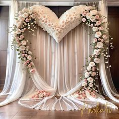 a heart - shaped backdrop with flowers and sheer drapes