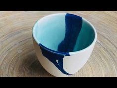 a blue and white cup sitting on top of a wooden table