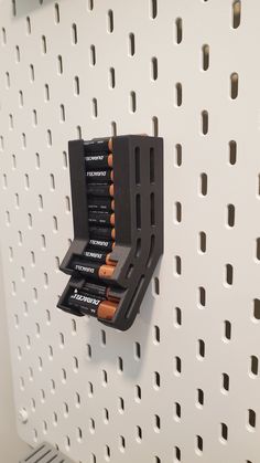 there are many batteries on the wall and one is in an holder for them to charge