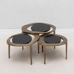 three tables with black top and metal legs on the floor in front of a white wall