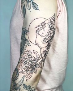 a man's arm with flowers and birds tattooed on the arm, while he is wearing