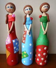 three wooden dolls standing next to each other