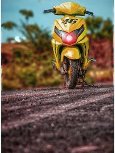 a yellow motorcycle parked on top of a dirt road