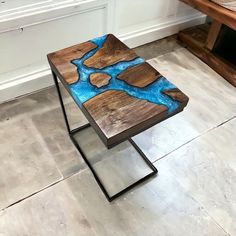 a wooden bench sitting on top of a tile floor next to a table with blue paint