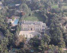 an aerial view of a mansion surrounded by trees