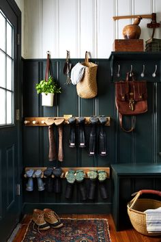 an entryway with shoes and umbrellas hanging from the hooks on the coat rack