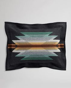 a black pillow with an abstract design on it