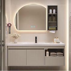 a bathroom with a sink, mirror and towel dispenser on the wall