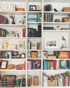 a bookshelf filled with lots of books and baskets on top of it's shelves