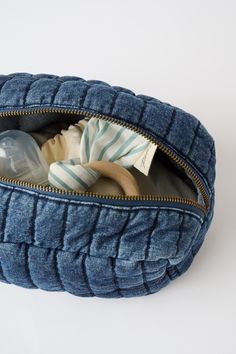 a blue bag filled with baby items sitting on top of a white table