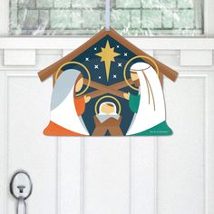 a door hanger with the nativity scene hanging from it's front door