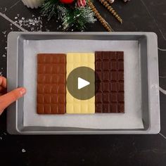 someone is pointing at some chocolates on a tray