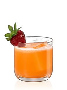 a glass filled with orange juice and a strawberry on top