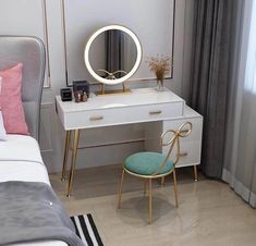 a bedroom with a bed, desk and mirror on it's side table in front of a window