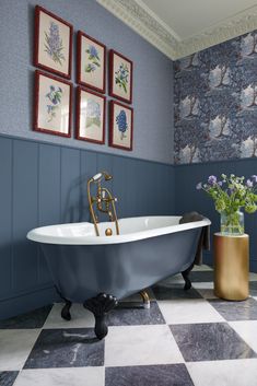 a bathroom with blue and white walls, checkered flooring and a claw foot bathtub