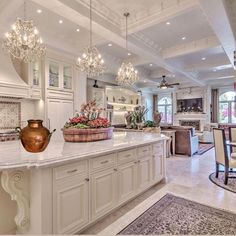 a large kitchen with an island and chandelier hanging from it's ceiling