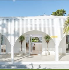 a white building with palm trees in the courtyard