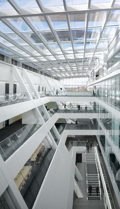 the interior of an office building with glass walls and staircases leading up to two levels