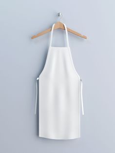 a white apron hanging on a wooden hanger against a gray wall with an empty space for text