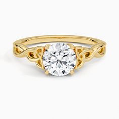 a yellow gold engagement ring with an oval cut diamond in the center and two leaves on each side